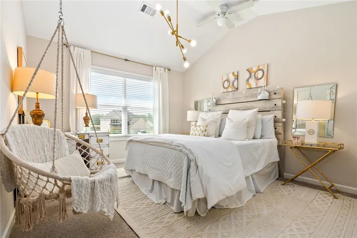 This airy bedroom features vaulted ceilings and ample natural light, creating a bright and inviting retreat.