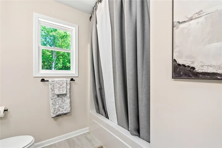 Bright bathroom with a large window and modern fixtures.