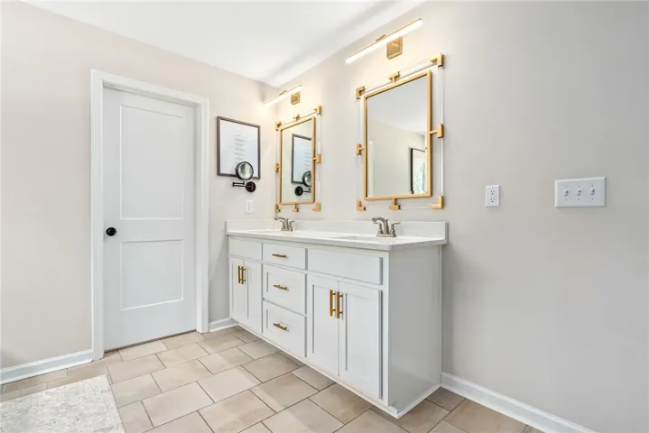 This primary bathroom features a double vanity and sleek modern finishes.