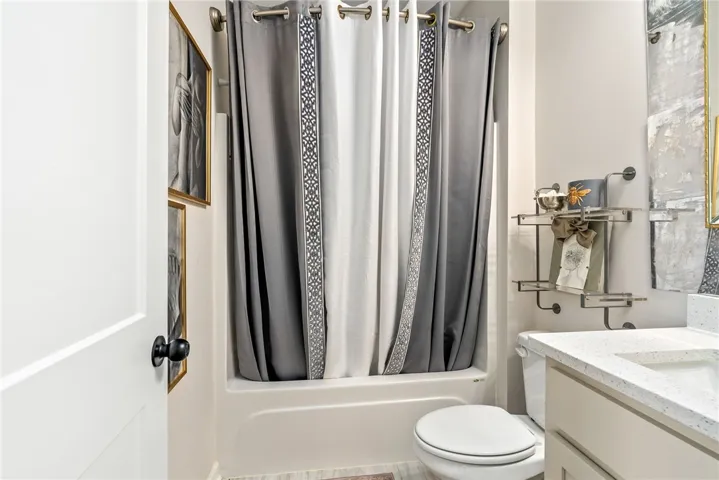 This bright bathroom features a functional tub and shower combination with elegant details.