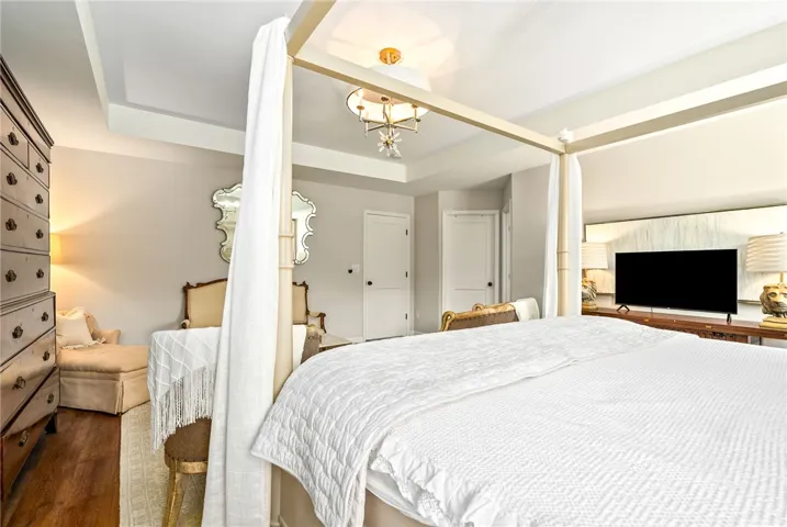 This spacious bedroom offers high ceilings and beautiful hardwood flooring.