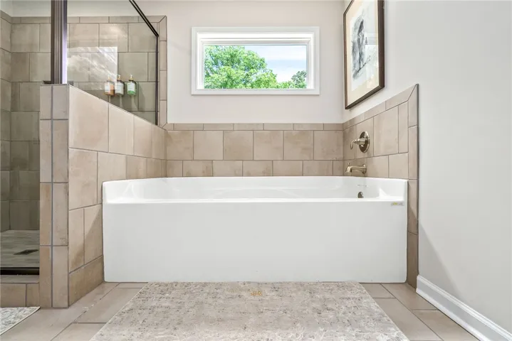 Relax in this modern bathroom with a soaking tub and a spacious walk-in shower.