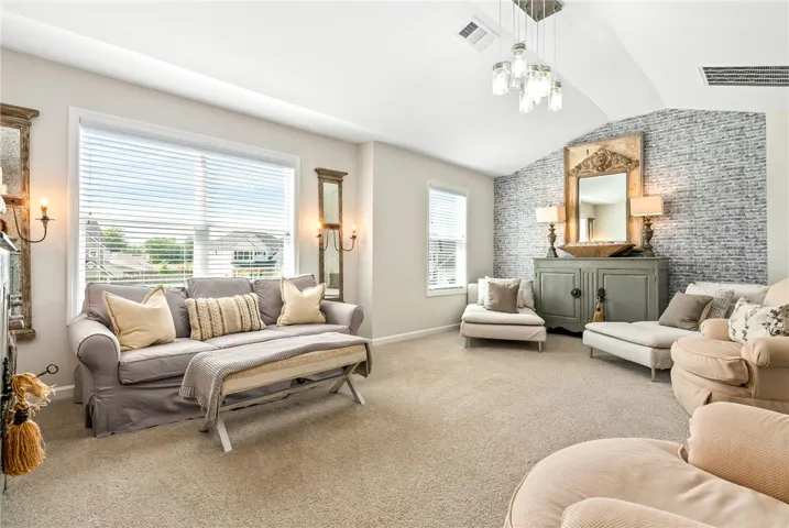 This living area features vaulted ceilings and a textured accent wall, creating a spacious and inviting atmosphere.