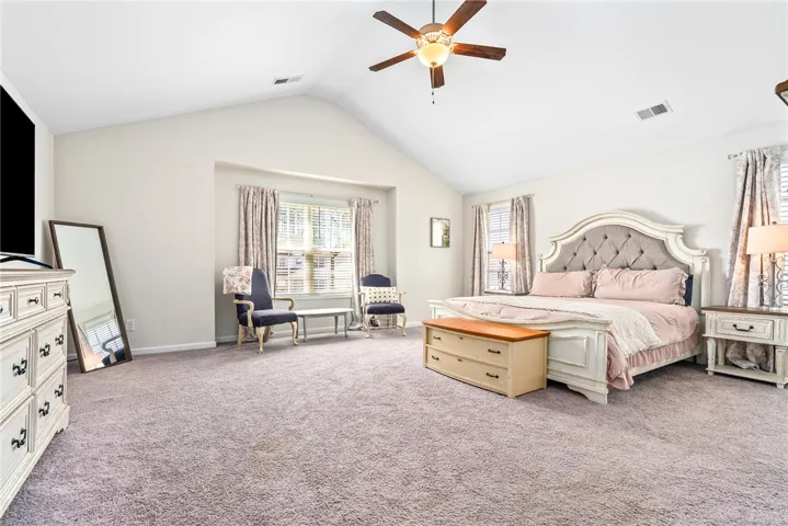 This expansive bedroom features vaulted ceilings and ample natural light, creating a bright and inviting retreat.