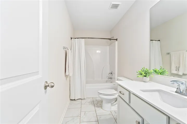 This bathroom offers a crisp, clean aesthetic with practical fixtures and elegant tilework.
