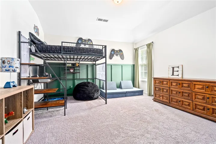 This spacious bedroom features a versatile layout, perfect for rest and recreation.