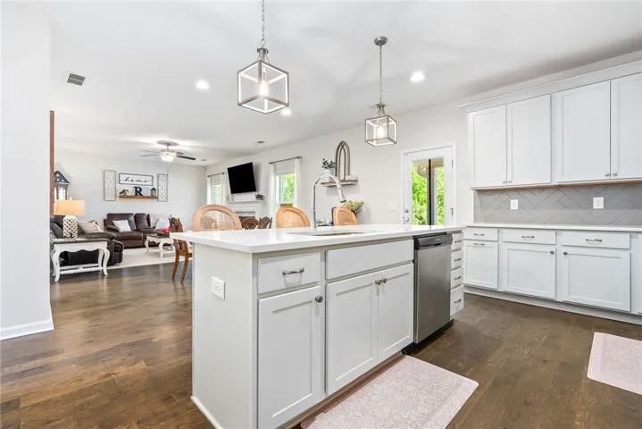 This bright kitchen features an island, ample cabinetry, and rich hardwood flooring, creating an inviting space.