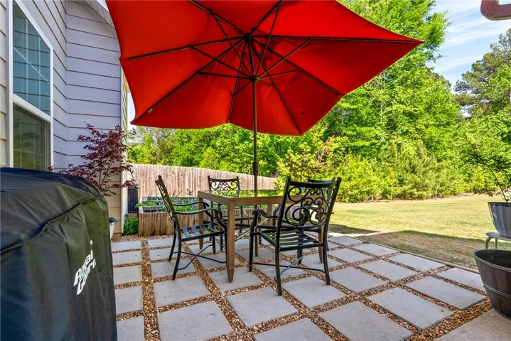 This private patio area offers a seamless extension of indoor living to the lush backyard.