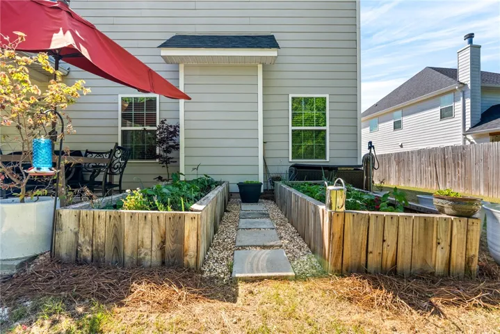 This private yard features raised garden beds and a charming patio for outdoor enjoyment.