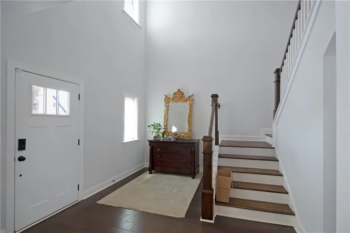 This bright entry offers a welcoming ambiance, leading to an elegant staircase.
