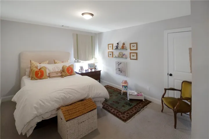 This cozy bedroom offers a tranquil retreat with soft lighting and comfortable carpeting.