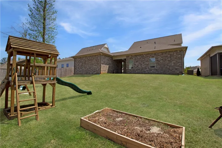 This spacious backyard features a vibrant green lawn and inviting outdoor amenities.