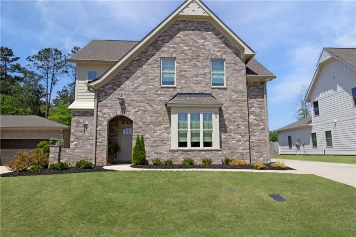 This charming residence features an inviting arched entryway and classic brick construction.