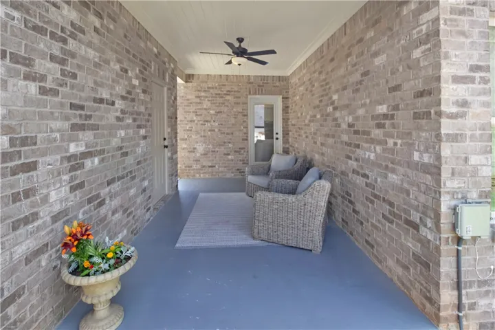 This inviting porch, perfect for quiet moments, features durable brick construction and elegant ceiling details.