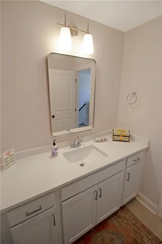 This sleek bathroom features ample counter space and a classic vanity with modern lighting.