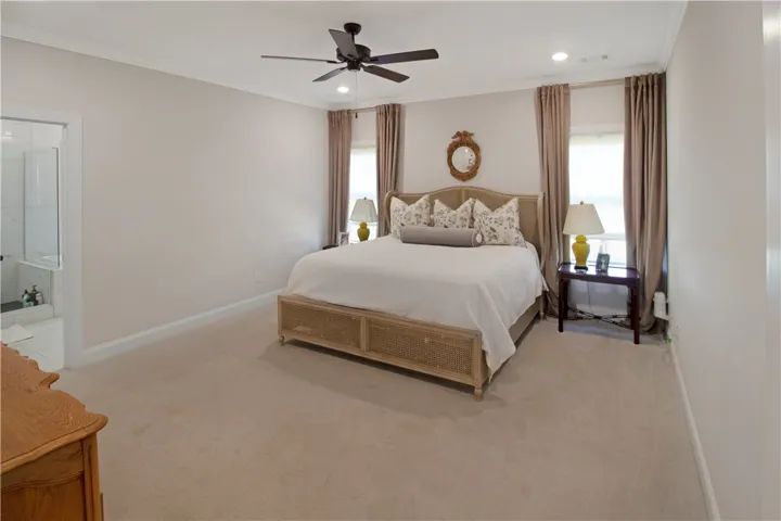 This tranquil bedroom features plush carpeting and direct access to a private bathroom.