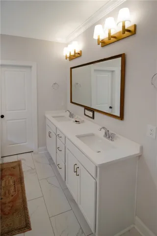 This bright bathroom offers a dual vanity with ample counter space and modern lighting.