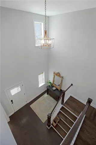 The foyer showcases rich hardwood floors and a striking overhead chandelier.