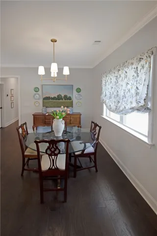 This elegant dining area boasts beautiful dark wood flooring, ideal for entertaining.