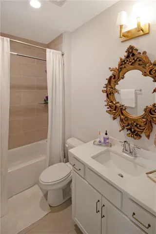Bright and inviting bathroom featuring a sleek vanity and a tiled shower-tub combination.