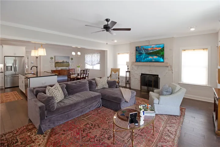 This inviting space features an open layout with a cozy fireplace and rich hardwood flooring.