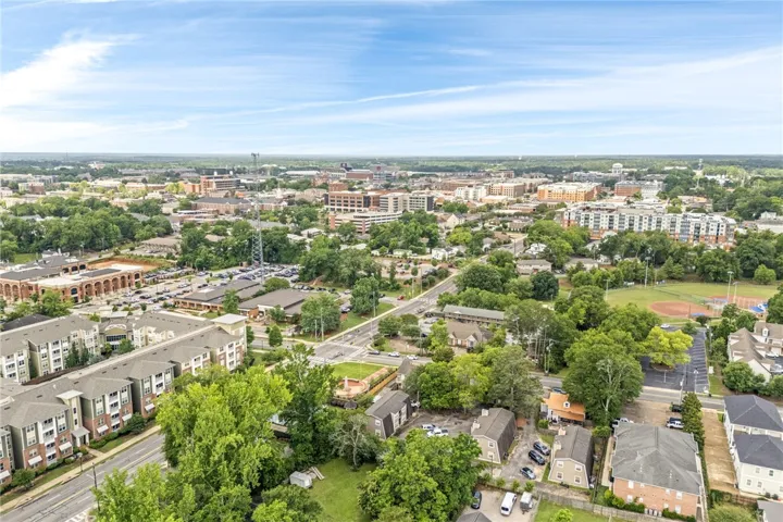 An aerial perspective reveals a vibrant neighborhood with diverse structures nestled amongst lush trees and green spaces.