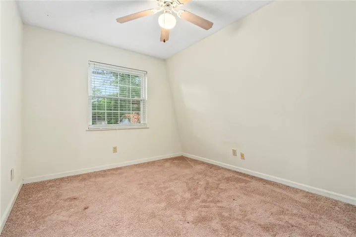 An inviting sleeping space with warm carpet underfoot and a convenient window for natural light.