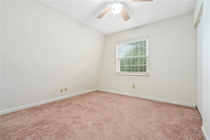A well-lit bedroom offering a warm, inviting atmosphere with plush carpeting.