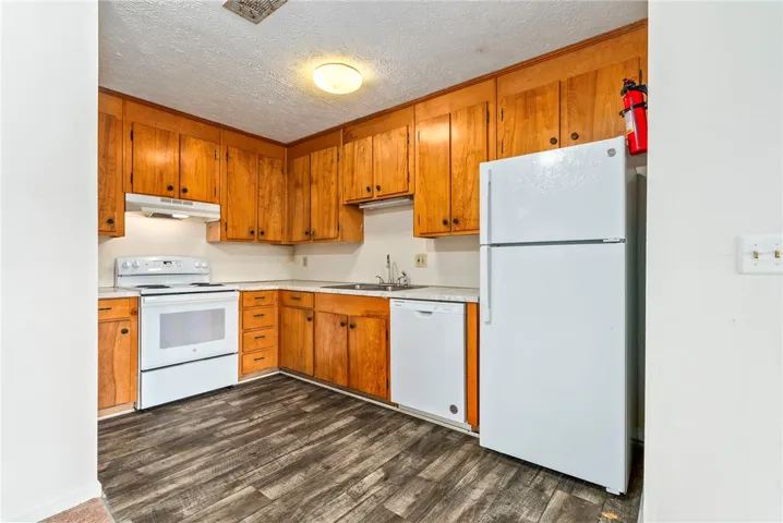A well-appointed kitchen showcasing classic wood cabinetry and durable flooring.