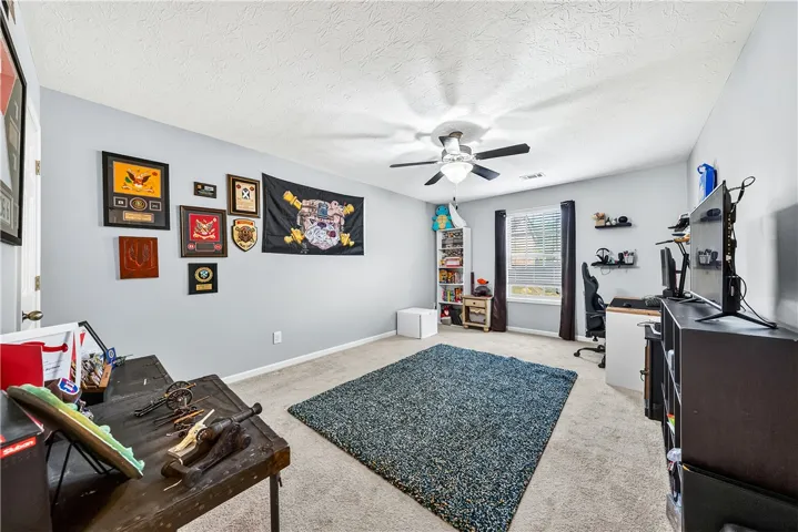 This spacious bedroom offers ample natural light and a comfortable atmosphere for relaxation.