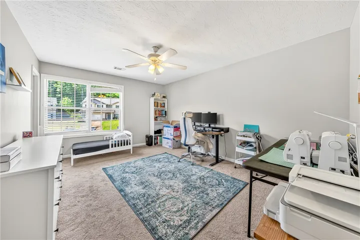 This versatile room offers ample natural light and plush carpeting, perfect for a home office or creative space.
