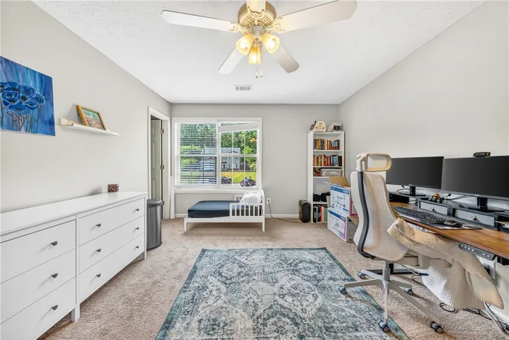This versatile room features an overhead fan and carpet flooring, offering a comfortable and adaptable living space.