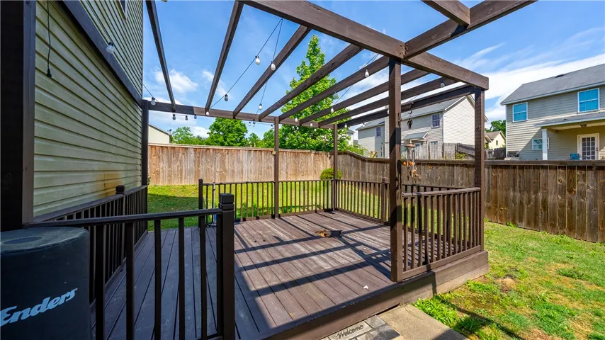 This spacious wooden deck offers an inviting outdoor retreat for relaxation and entertainment.
