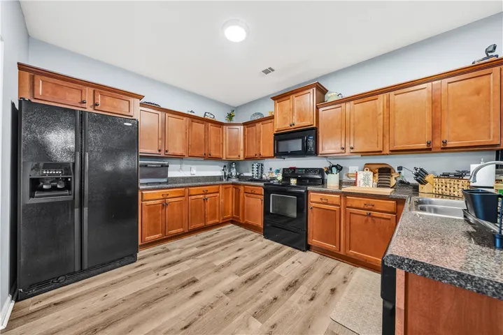 This spacious kitchen offers ample cabinetry, modern appliances, and durable flooring for everyday living.
