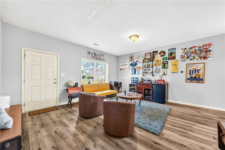 This inviting room features warm wood flooring and a classic door, offering a comfortable living space.