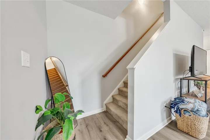 This interior features a well-maintained staircase and beautiful flooring.