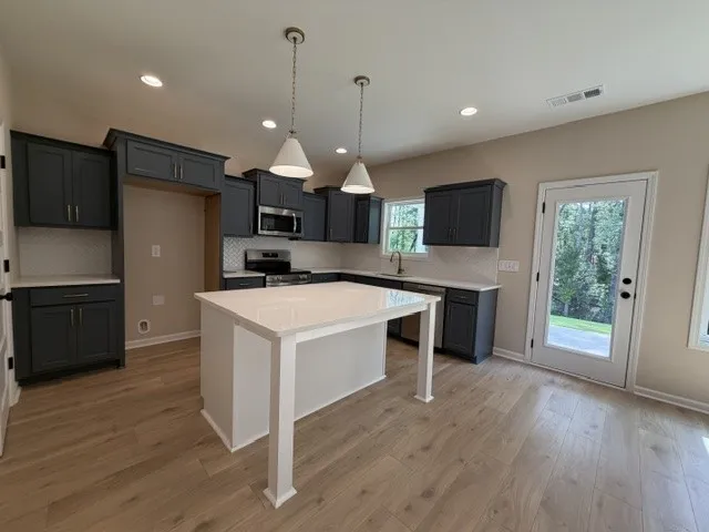 A contemporary kitchen features an inviting island, ample cabinetry, and a bright view to the outdoors.