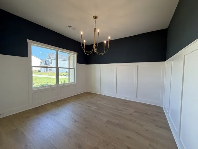 Board and batten wainscoting and wide plank flooring define this inviting dining area.