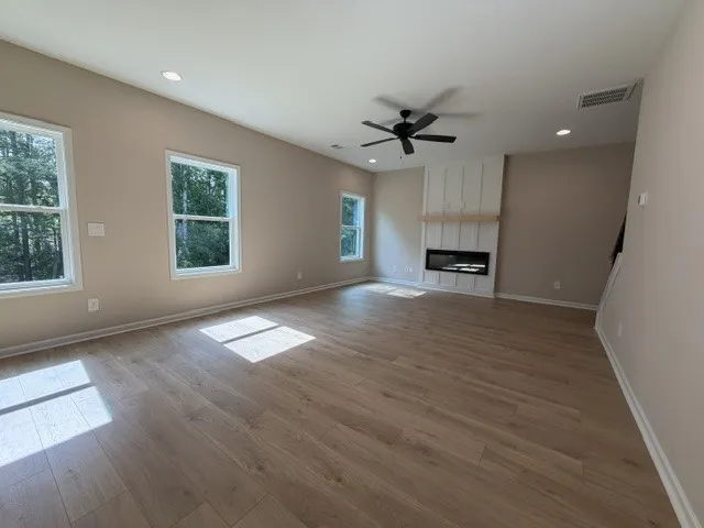 Sun-filled interiors complement light hardwood flooring and a sleek modern fireplace.