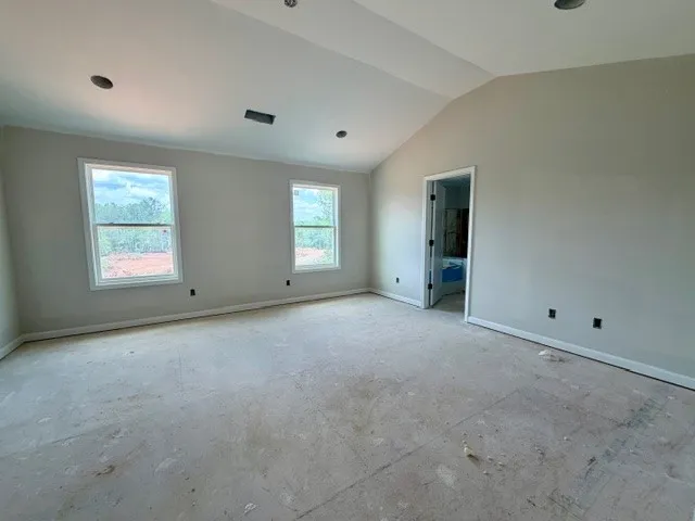 This spacious bedroom offers ample natural light and vaulted ceilings.