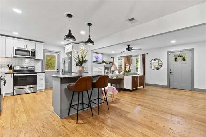 An inviting open-concept living area boasts a kitchen island and sleek appliances.