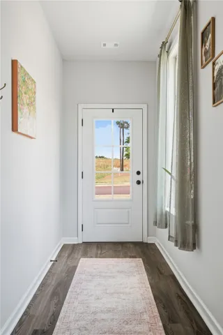 This inviting entryway features natural light, sleek flooring, and ample wall space.
