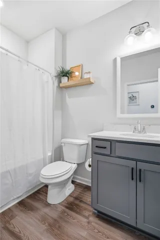 This bathroom features durable flooring and a stylish vanity, perfect for daily routines.