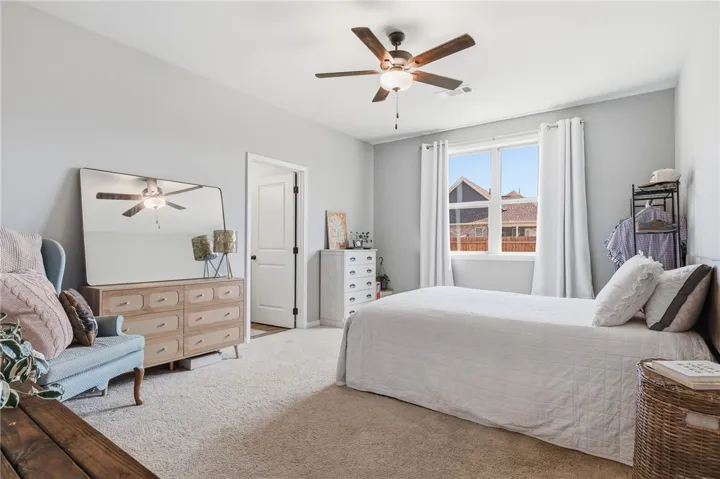 The primary bedroom is spacious with a large window overlooking the backyard.