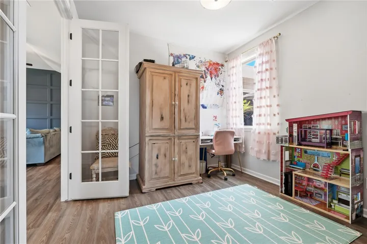 This versatile room features warm flooring and ample natural light, ideal for a flexible living space.