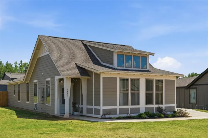 This charming residence features appealing architectural details, including a dormer and an inviting front porch.