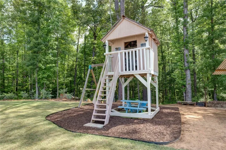 This charming play structure provides an imaginative retreat within a serene, wooded setting.