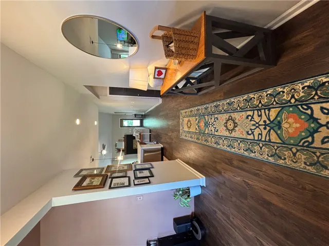 Warm wood floors and modern lighting create an inviting entry.