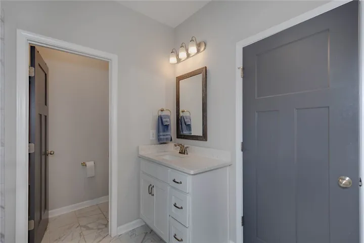This bathroom features a contemporary vanity and elegant tile flooring.