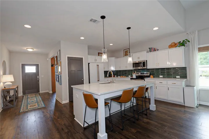 This modern kitchen features a spacious island and gleaming appliances, perfect for everyday living.